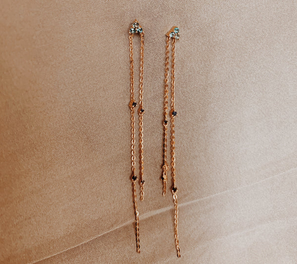 Rose gold dangle earrings with two cable chains dropped with topaz and black sapphire gems.
