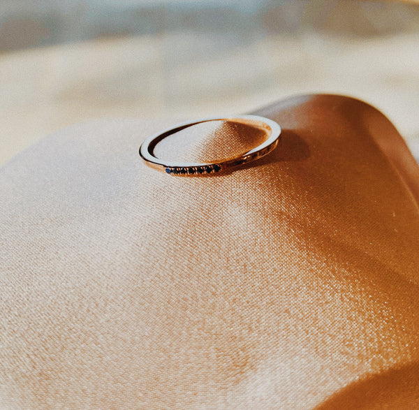 Rose gold ring band with seven black sapphires. 