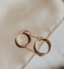 Two rose gold rings connected by a chain and meant to be worn on the same finger.