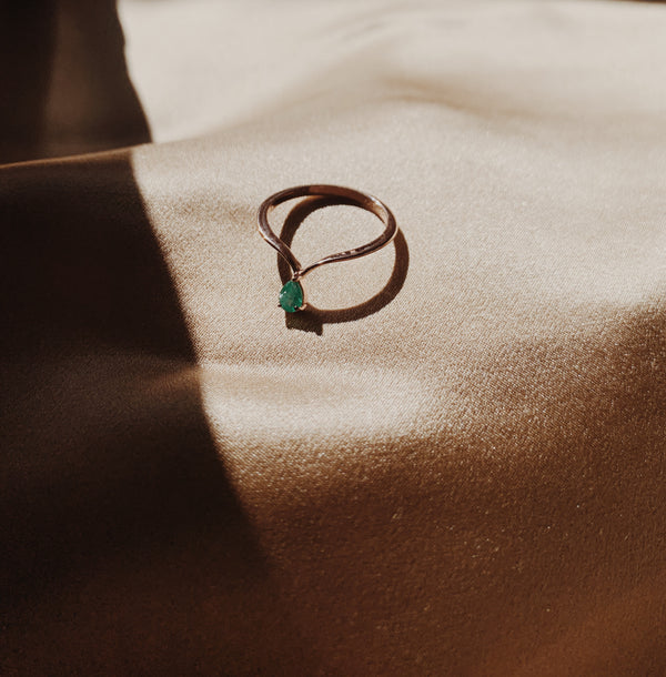 Rose gold midi ring with a pear shaped emerald gem.