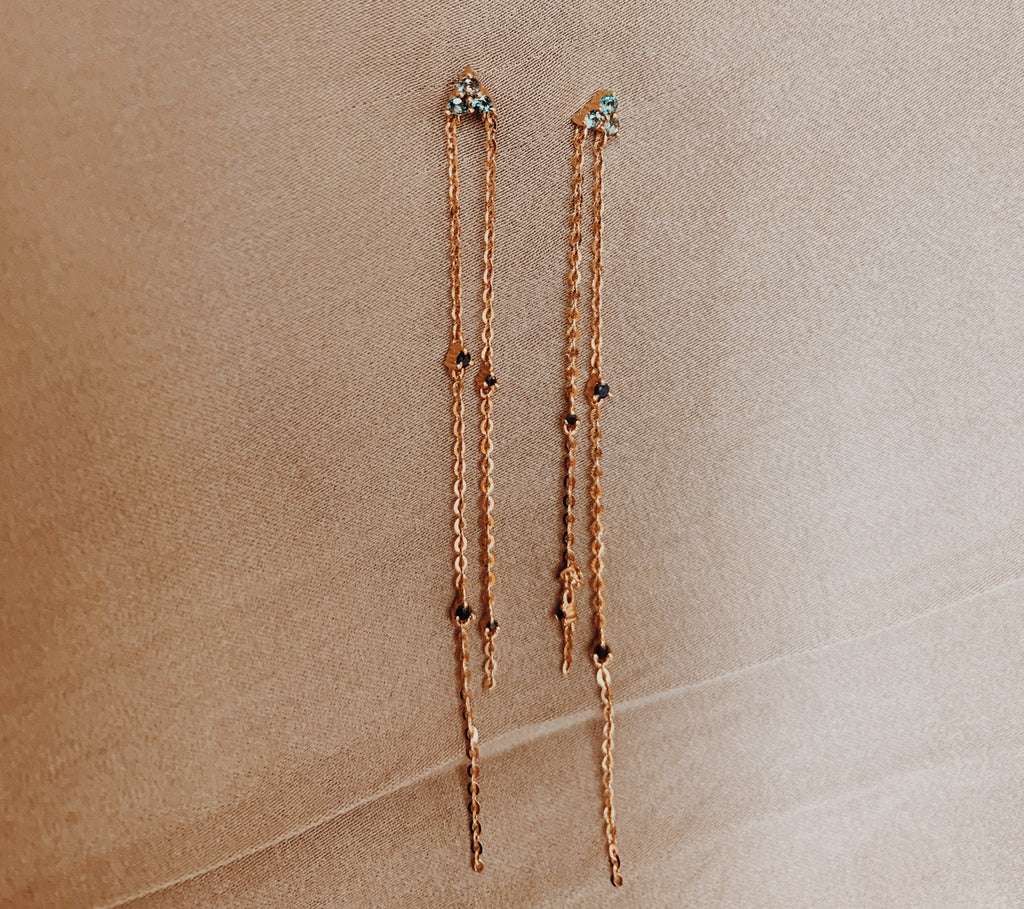 Rose gold dangle earrings with two cable chains dropped with topaz and black sapphire gems.